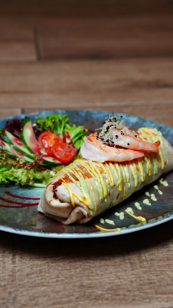 Burrito with salad on the plate