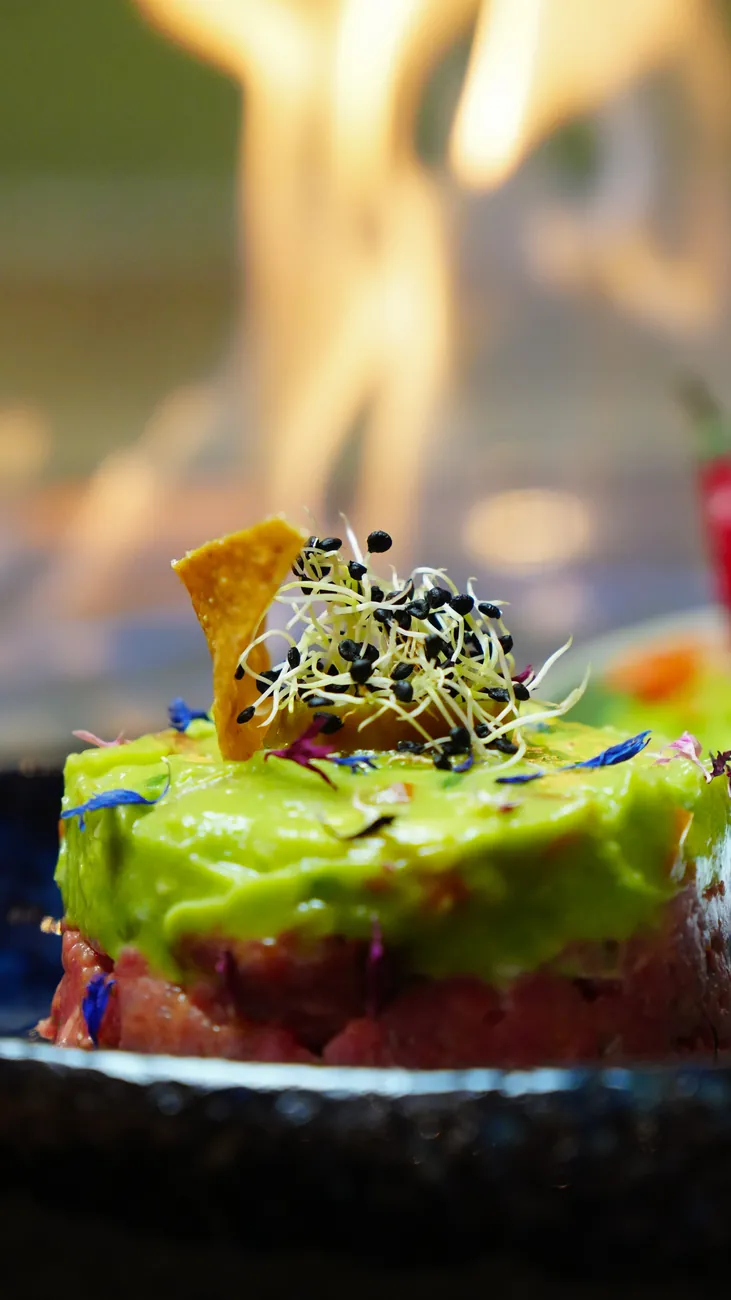 Tartare with avocado in front of an open flame